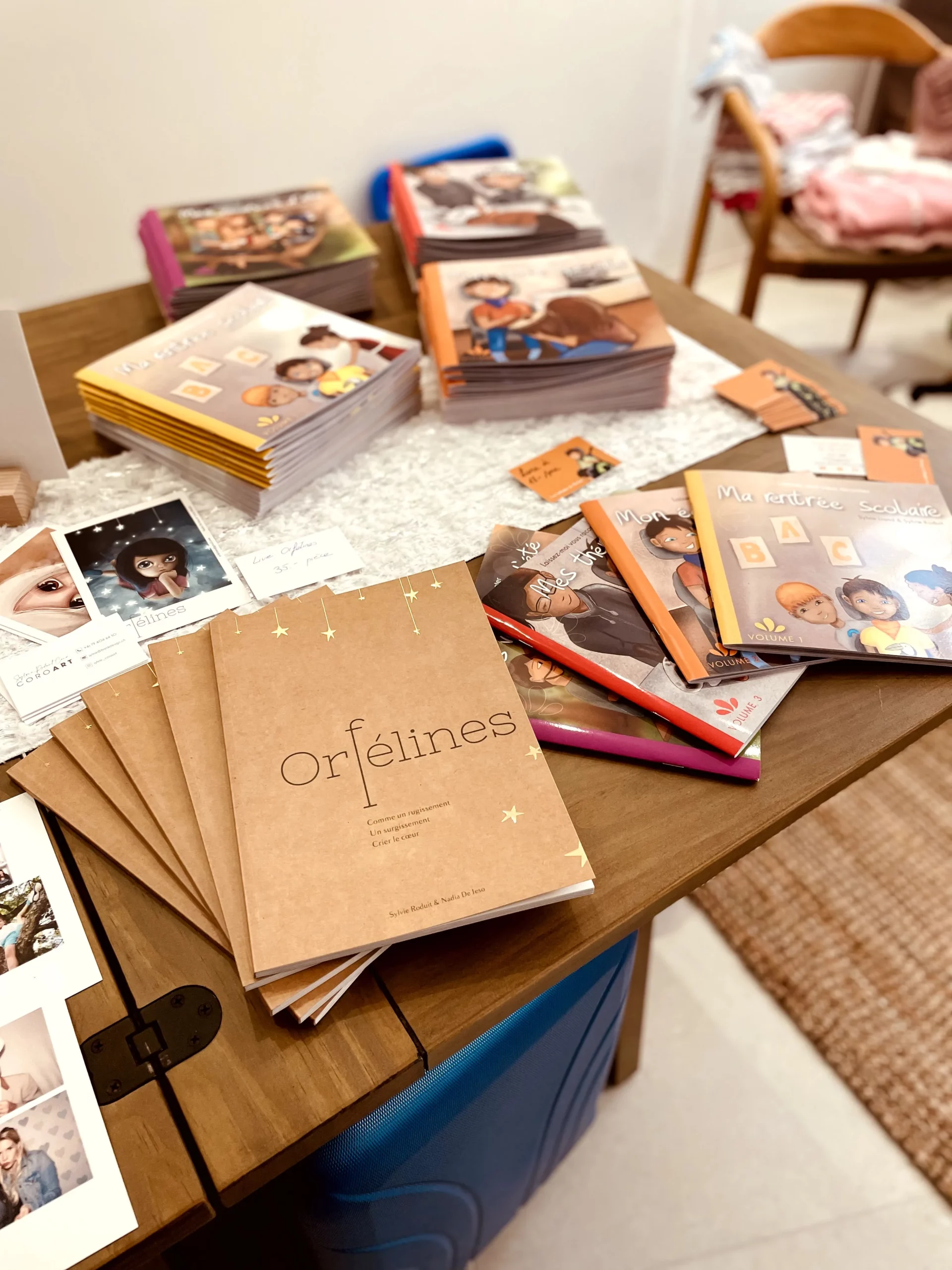 Livres illustrés, cartes et créations artistiques de Sylvie Roduit exposés sur un présentoir CoroArt.